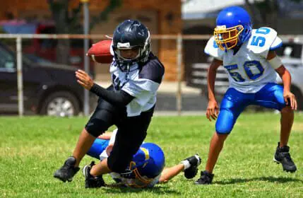 Blog 3 Young american football player running back breaking away from an attempted tackle.
