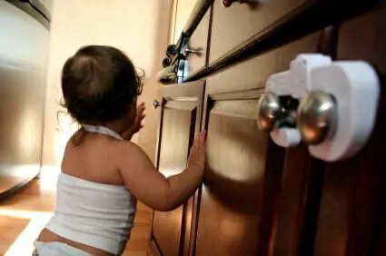 Clorox Recalls 5.4 Million Bottles of Liquid Plumr 1 Baby resting on childproofed wooden kitchen cabinets