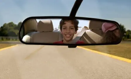 Blog 18 Child looking and smiling into rearview mirror