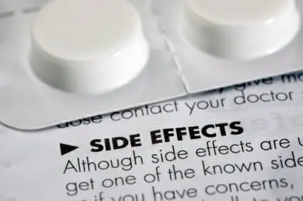 Side effects leaflet with a tablet container sitting on top