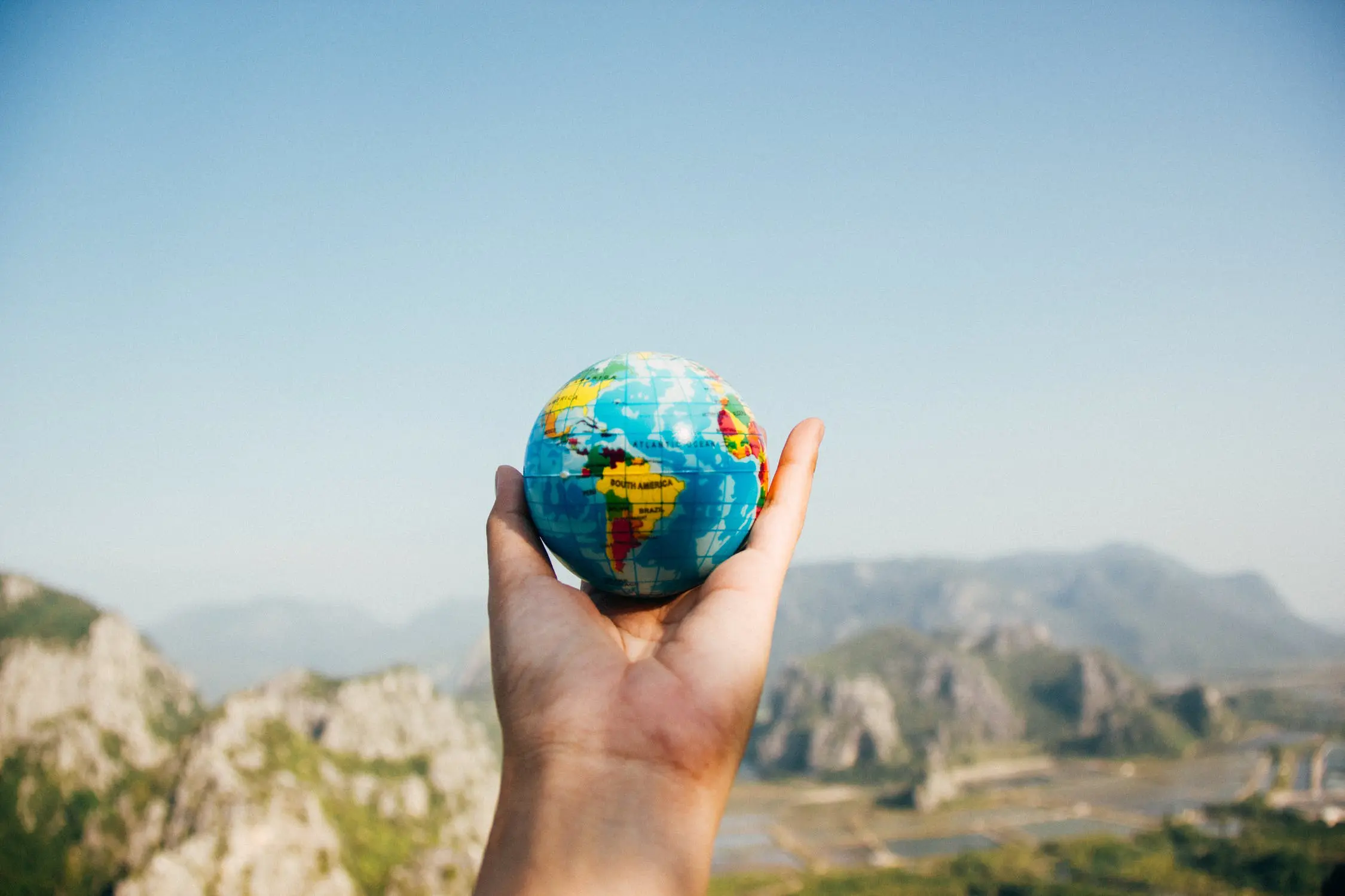 5 Quick Tips for Going Green on Earth Day 1 Person Holding World Globe Facing Mountain
