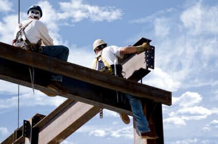 Two Hospitalized Following Construction Accident at Mather Airport 1 Two ironworkers atop the skeleton of a modern building. One man is positioning a very large beam while the other watches.