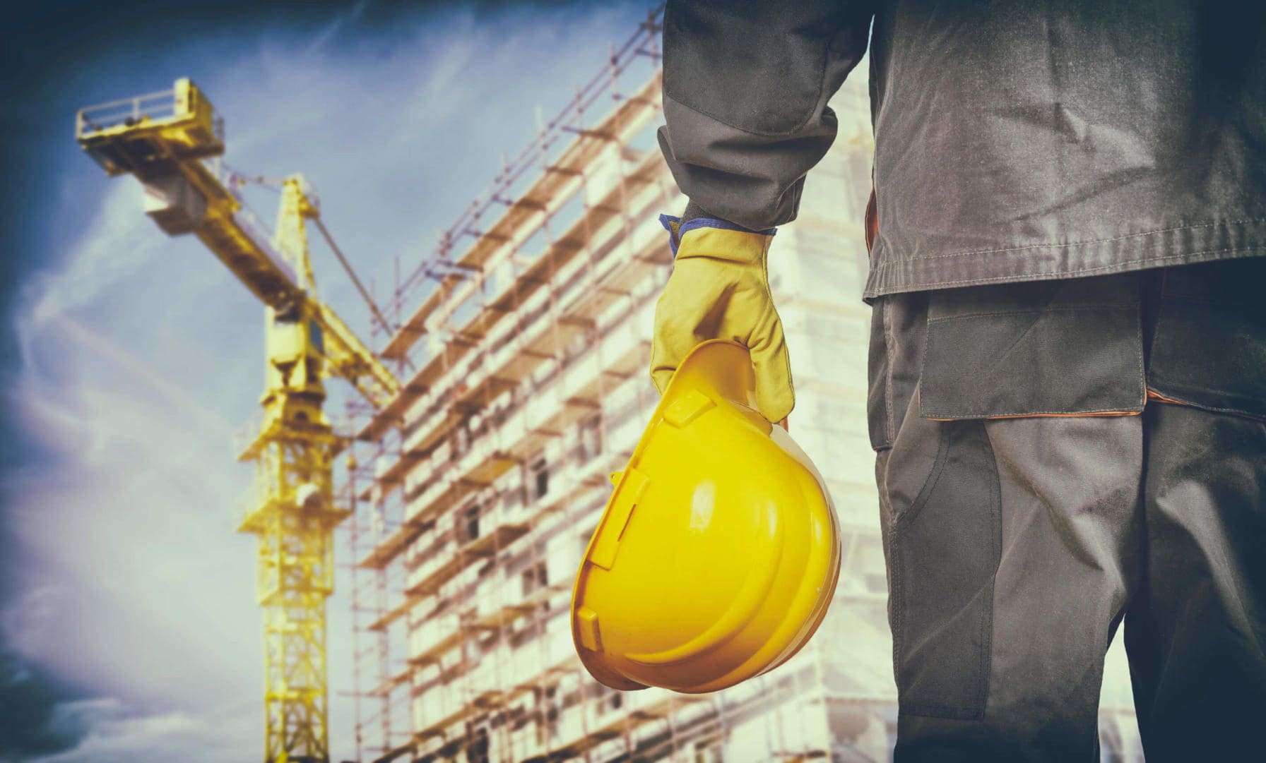 Worker Killed at Highway 169 Construction Site 1 Construction worker with protective uniform in front of construction scaffolding and construction crane
