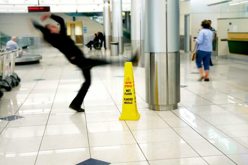 Rear-End Collisions in Texas: Who's Really at Fault? 17 Person in shopping center slipping and falling next to a caution wet floor sign