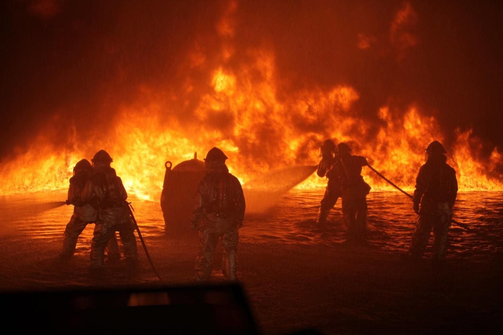 Industrial fire being put out by fire fighters