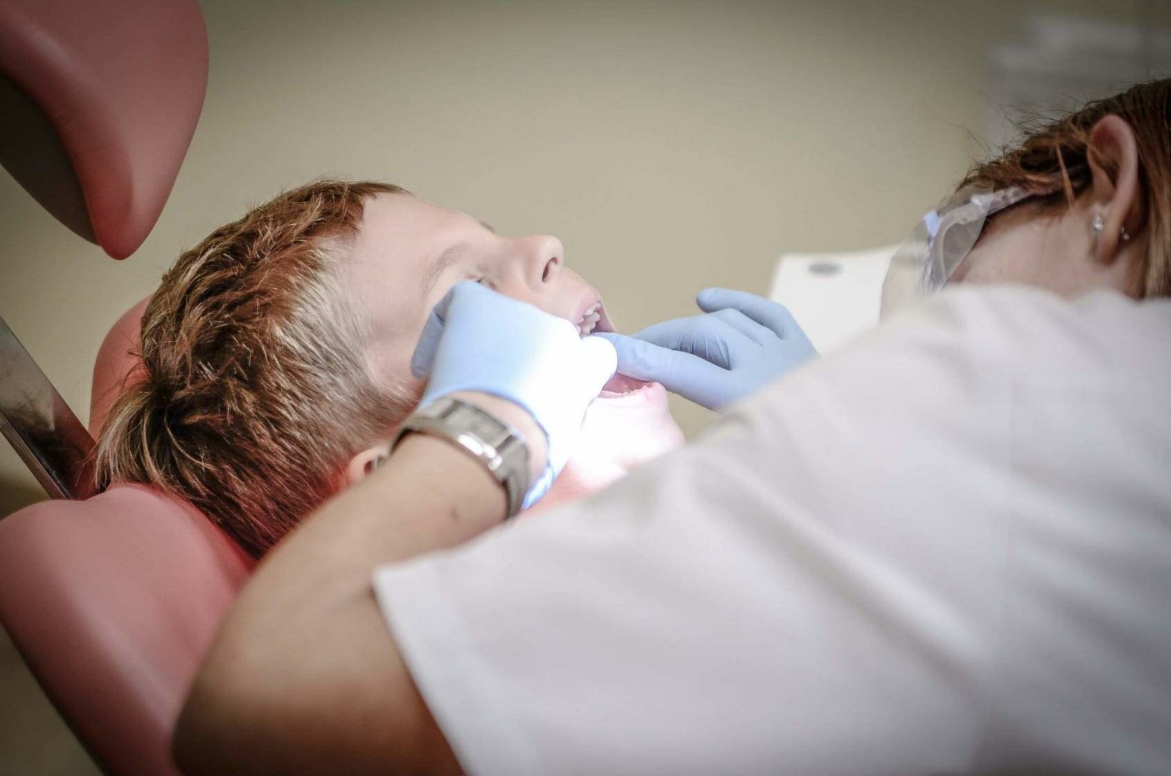 Dentist Allegedly Sets Fire in the Mouth of a 5-Year-Old Girl 1 Dentist looking into child's mouth