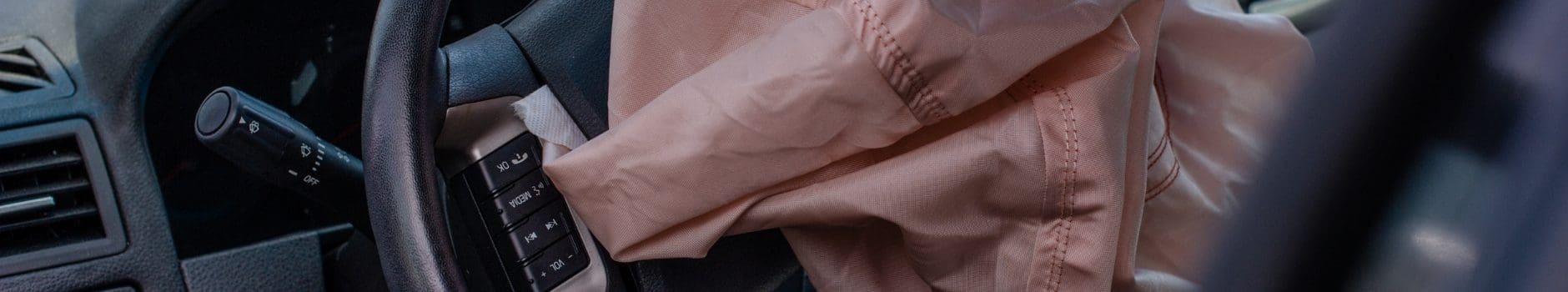 NHTSA Steps in as Company Refuses to Recall Potentially Deadly Airbag Inflators 1 Close-up of steering wheel with pink airbag deployed